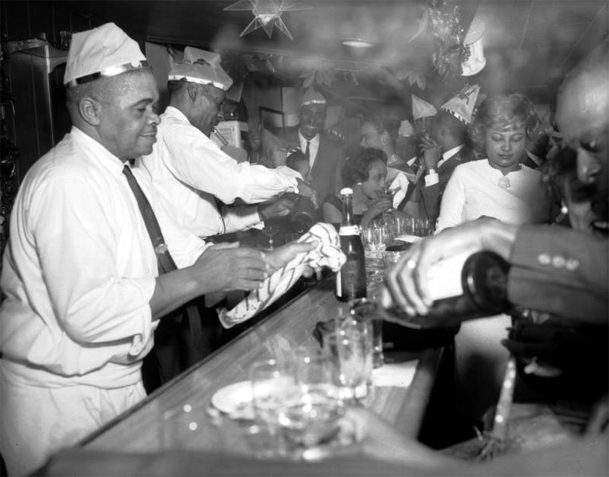 Photo of a group of men and women revelers gather at a bar on New Years Eve in Denver, Colorado, (ca. 1965). Source: Burnis McCloud/ Denver Public Library/Western History Collection/MCD-199.